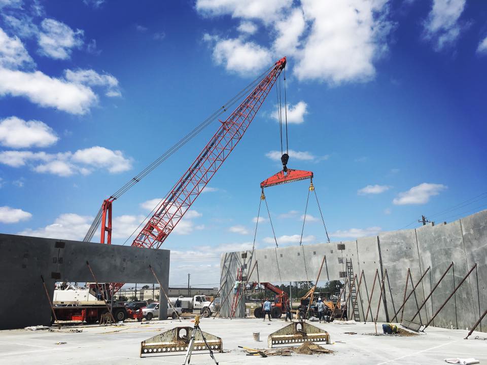 A crane lifts material on a concrete job site.